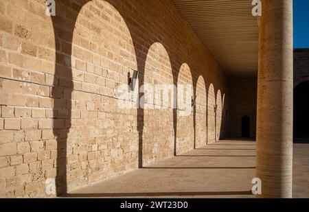 The shadows of traditional Islamic horseshoe arches along the side of the sahn, or courtyard,  in the Great Mosque of Mahdia, Tunisia. Stock Photo