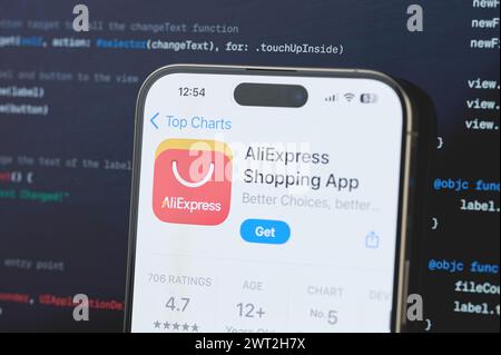 New York, USA - February 23, 2024: AliExpress on iphone screen in blurred code programming background Stock Photo