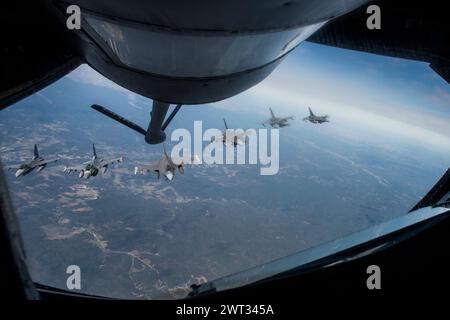 A formation of six F-16 Fighting Falcons from the 180th Fighter Wing in Toledo, Ohio fly behind a KC-135 Stratotanker from 121st Air Refueling Wing Stock Photo