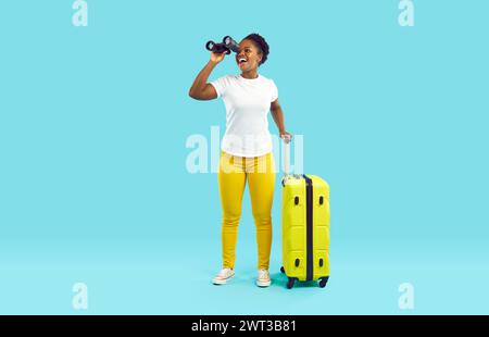 Female African-American traveler with binoculars showing silence ...
