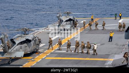 EAST CHINA SEA (March 9, 2024) Marines from the 31st Marine Expeditionary Unit board MH-60S Sea Hawk helicopters from Helicopter Sea Combat Squadron Stock Photo