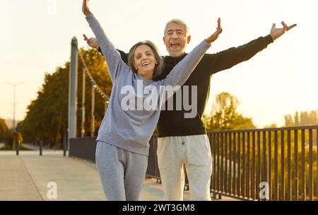 Happy senior man and woman are having fun during outdoor fitness workout in summer Stock Photo