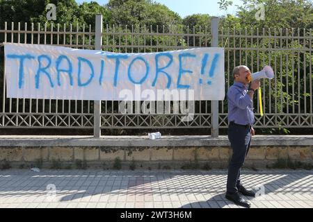 A man, with a megaphone, in front of a banner that says 'traitor', protests against the arrival of the Minister of the Interior, Matteo Salvini, at th Stock Photo