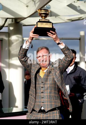 Greg Turley husband of owner Audrey Turley celebrates with the trophy after Galopin Des Champs ridden by jockey Paul Townend wins the Boodles Cheltenham Gold Cup Chase on day four of the 2024 Cheltenham Festival at Cheltenham Racecourse. Picture date: Friday March 15, 2024. Stock Photo