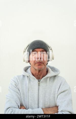 Man wearing headphones with eyes closed listening to music. Stock Photo