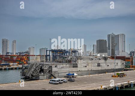 Cartagena, Colombia - July 25, 2023: Roll-on roll-off ship docked on cruise terminal pier with SPRC container terminal and tall buildings cityscape in Stock Photo