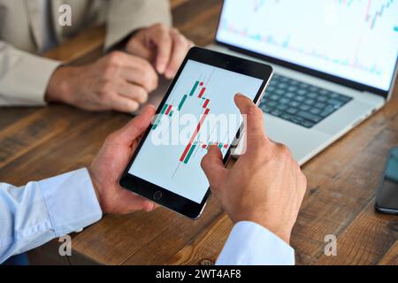 Stock market investor analyzing trade charts invest trends on tablet, close up. Stock Photo