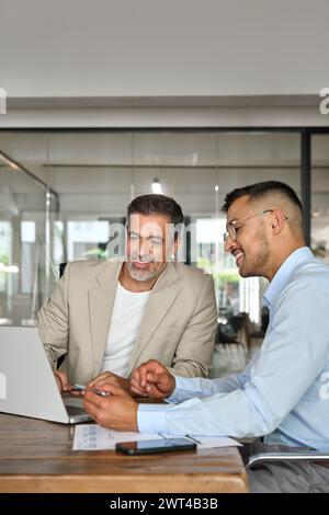 Happy business team people of two executive men working in office on laptop. Stock Photo