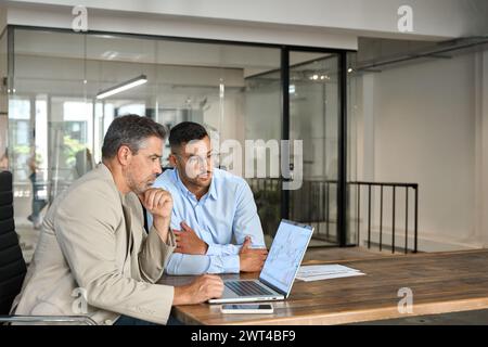 Two busy investors invest in financial stock market using laptop. Copy space. Stock Photo