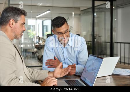 Advisor consulting investor about stock market financial investing using laptop. Stock Photo