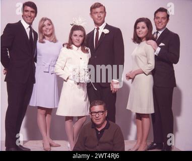 Portrait of the principal cast members of VALLEY OF THE DOLLS 1967 with director MARK ROBSON sitting in front of them. From left to right they are TONY SCOTTI, SHARON TATE, PATTY DUKE, MARTIN MILNER, BARBARA PARKINS and PAUL BURKE. Novel JACQUELINE SUSANN Costume Design TRAVILLA 20th Century Fox Stock Photo