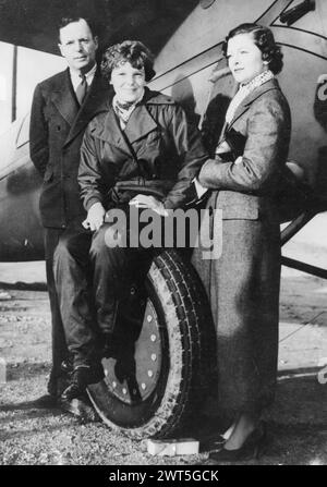 January 2, 1935, New York, New York, USA: American aviation pioneer and women's rights advocate AMELIA EARHART, who set numerous records, including being the first woman to fly solo across the Atlantic, pictured sitting on an airplane wheel next to her husband GEORGE PUTNAM and an actress MIRNA LOY, who was filming 'Wings in the Dark' with Carey Grant. The movie is not one of Grant or Loy‚Äôs best films. But it is memorable for a photo shoot that occurred during filming when Amelia Earhart stopped by the set for a visit with the stars. (Credit Image: ¬ © Keystone Press Agency/ZUMA Press Wire)  Stock Photo