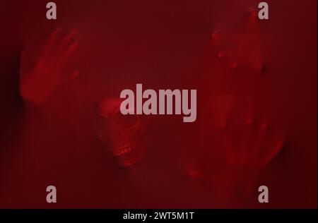 Silhouette of creepy ghost with skull behind red cloth Stock Photo