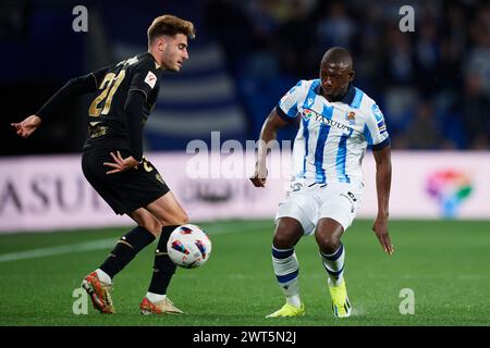 Robert Navarro of Cadiz CF compete for the ball with Hamari Traore of Real Sociedad during the LaLiga EA Sports match between Real Sociedad and Cadiz CF at Reale Arena Stadium on March 15, 2024, in San Sebastian, Spain. Credit: Cesar Ortiz Gonzalez/Alamy Live News Stock Photo