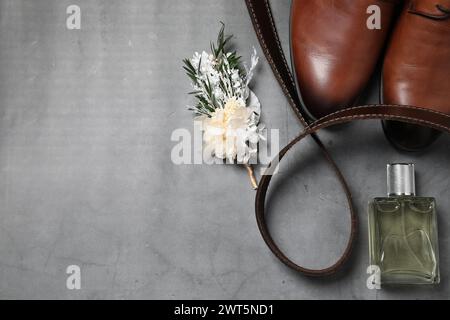 Wedding stuff. Flat lay composition with stylish boutonniere on gray background, space for text Stock Photo