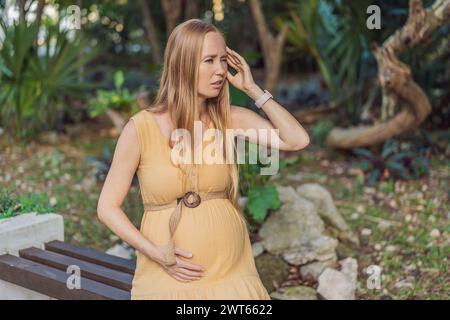 A pregnant woman experiences a moment of discomfort, grappling with a headache during pregnancy, highlighting the common challenge and the need for Stock Photo