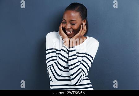 Shy, thinking and black woman with a smile, ideas and model on a grey studio background. African person, mockup space and girl with solution or Stock Photo