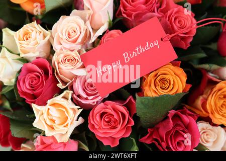 Bouquet of beautiful roses with Happy Birthday card, top view Stock Photo