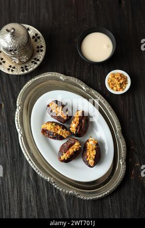 Dates Fruit Stuffed with Chopped Pistachio Peanuts and Cream Cheese. Top View on Wooden Table Stock Photo