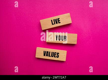 Live your values words written on wooden blocks with pink background. Conceptual symbol. Copy space. Stock Photo