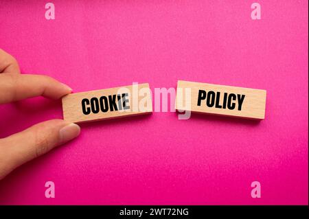 Cookie policy words written on wooden blocks with pink background. Conceptual symbol. Copy space. Stock Photo