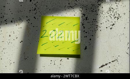 Text with the words "2021" on a note pasted on the wall Stock Photo