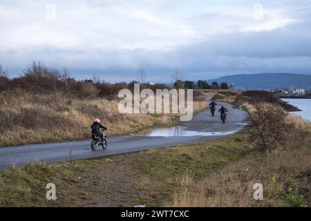 Boys on dirt bikes ride on track beside the river Tees, in Port Clarence. Teesside, North East England, UK. Stock Photo