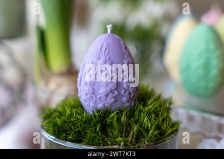Colorful easter egg soy wax candle. Spring background Stock Photo