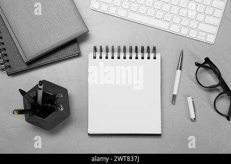 Flat lay composition with notebooks and glasses on light grey table Stock Photo