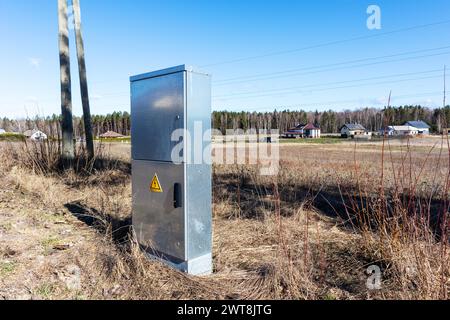 Metal electrical distribution box on field background Stock Photo