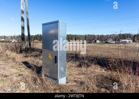 Metal electrical distribution box on field background Stock Photo