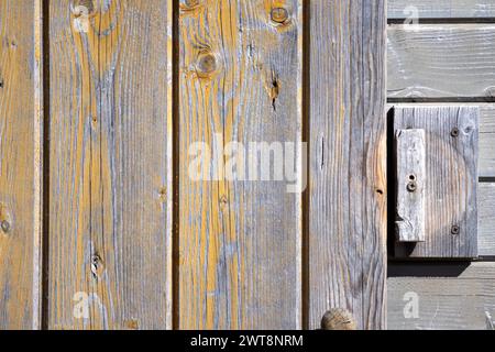 A wall of wooden planks with a wooden handle for closing the door Stock Photo