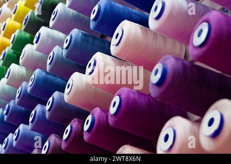 Assorted spools of multi-coloured cotton threads, abstract textile industry background Stock Photo