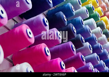 Assorted spools of multi-coloured cotton threads, abstract textile industry background Stock Photo