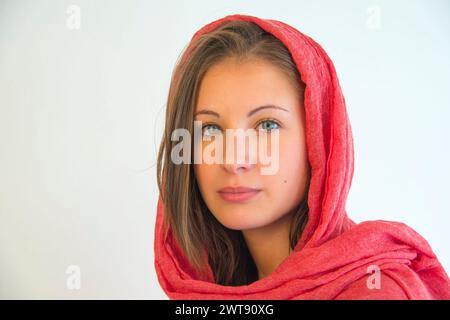 Portrait of blonde young woman wearing red shawl. Stock Photo