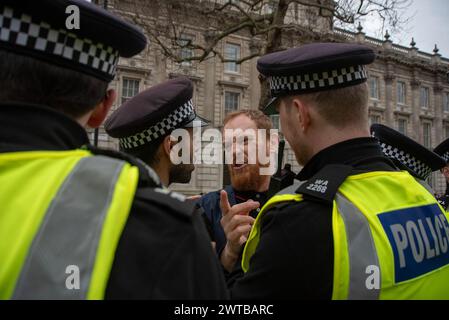 London, UK. 16th Mar, 2024. Police officers talk with the counter protester outside the Downing Street. Stand Up To Racism organisation organised a protest to the Home Office in London, UK. Demanding to stop islamophobia and deportation. After the protest the crowd marched to the Downing Street for a rave party. (Photo by Krisztian Elek/SOPA Images/Sipa USA) Credit: Sipa USA/Alamy Live News Stock Photo