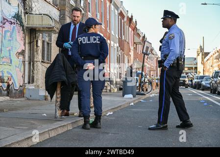 Philadelphia, United States. 16th Mar, 2024. Police block off roads and gather evidence as they investigate a shooting near the Kensington area in Philadelphia. One person was killed and one person wounded in a double shooting on East Lippincott Street in Philadelphia. A 25-year-old Hispanic male died from a gunshot wound to the chest and a 23-year-old Hispanic female was wounded by a graze wound to the left arm and is in stable condition. The shooting happened at approximately 3:27 PM, Saturday afternoon. (Photo by Kyle Mazza/SOPA Images/Sipa USA) Credit: Sipa USA/Alamy Live News Stock Photo