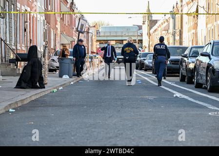 Philadelphia, United States. 16th Mar, 2024. Police block off roads and gather evidence as they investigate a shooting near the Kensington area in Philadelphia. One person was killed and one person wounded in a double shooting on East Lippincott Street in Philadelphia. A 25-year-old Hispanic male died from a gunshot wound to the chest and a 23-year-old Hispanic female was wounded by a graze wound to the left arm and is in stable condition. The shooting happened at approximately 3:27 PM, Saturday afternoon. (Photo by Kyle Mazza/SOPA Images/Sipa USA) Credit: Sipa USA/Alamy Live News Stock Photo