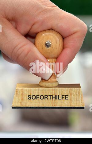 Symbol photo, woman's hand with stamp, inscription: Soforthilfe, Studio Stock Photo