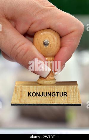 Symbol photo, woman's hand with stamp, inscription: Konjunktur, Studio Stock Photo