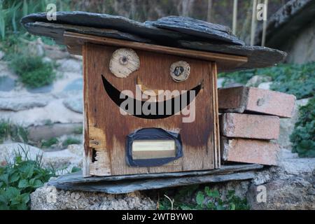 closeup on a fun and different wooden mailbox with a smile and a slate roof Stock Photo