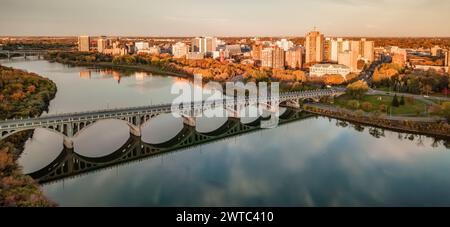 An aerial of a bridge over the Saskatchewan River with the city in the background in Saskatoon, SK, Canada Stock Photo