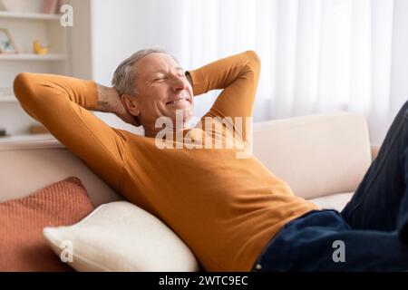 Relaxed elderly man reclining on couch at home Stock Photo