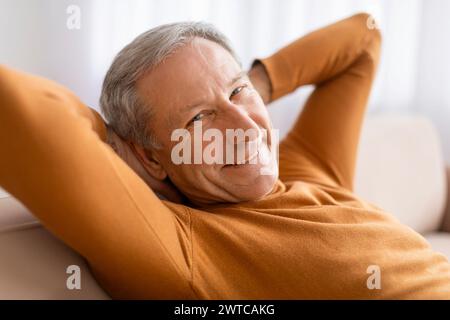Closeup of happy senior man chilling on sofa at home Stock Photo