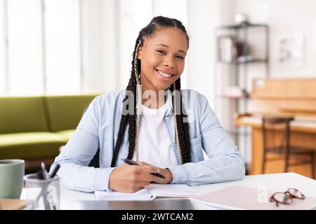 Smiling african american lady student studying at home Stock Photo
