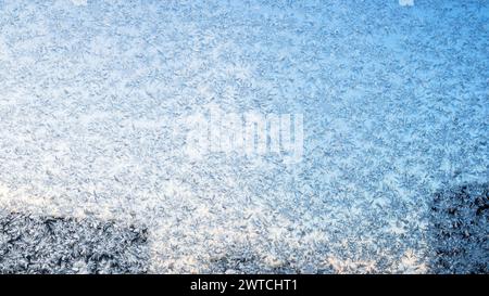 frost on window glass of city apartment on cold winter evening and blue sky on background Stock Photo