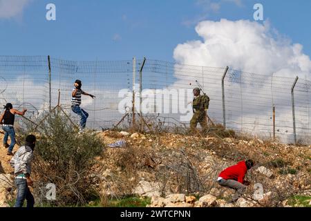 Bilin, Ramallah, Palestine. 7th Jan, 2011. Palestinian activists throw stones at IDF soldier during weekly Friday demonstrations against occupation of Palestinian territoriesÂ by Israel in Bilin, West Bank, Palestine on December 31, 2010. Bilin, a small village near Ramallah holds weekly protests as much of the local farmers' land was annexed by Israeli authorities to build a new Jewish settlement. (Credit Image: © Dominika Zarzycka/SOPA Images via ZUMA Press Wire) EDITORIAL USAGE ONLY! Not for Commercial USAGE! Stock Photo