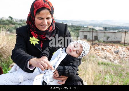 Bilin, Ramallah, Palestine. 7th Jan, 2011. Palestinian woman holds her baby during weekly Friday demonstrations against occupation of Palestinian territoriesÂ by Israel in Bilin, West Bank, Palestine on December 31, 2010. Bilin, a small village near Ramallah holds weekly protests as much of the local farmers' land was annexed by Israeli authorities to build a new Jewish settlement. (Credit Image: © Dominika Zarzycka/SOPA Images via ZUMA Press Wire) EDITORIAL USAGE ONLY! Not for Commercial USAGE! Stock Photo