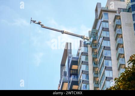 Aerial lift crane on roof, a straightened lift arm and a lifting platform for lifting goods to the upper floors, for example furniture and other heavy Stock Photo