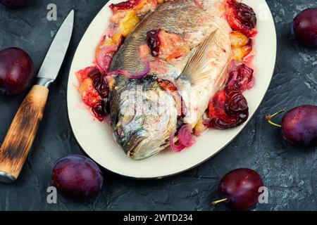 Dorado or sea bream fish baked with plums. Stock Photo